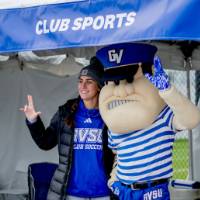 Louie gives the anchor up sign with an alum at the Club Sports tent